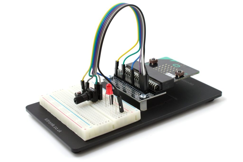 micro:bit 插在扩展板上，接到面包板做实验