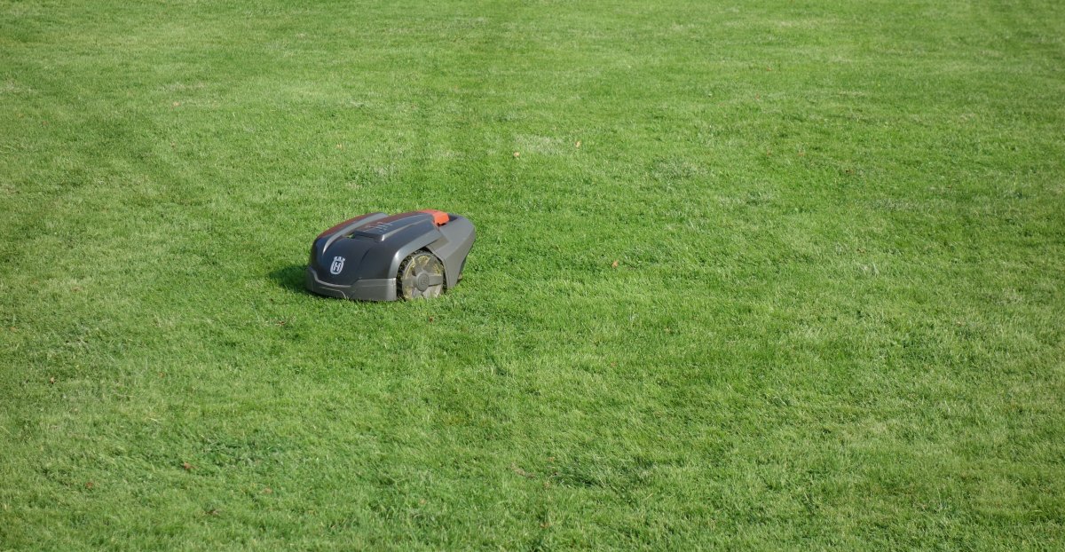 Husqvarna Automower 割草机器人在草坪上作业,地上可见其行走轨迹