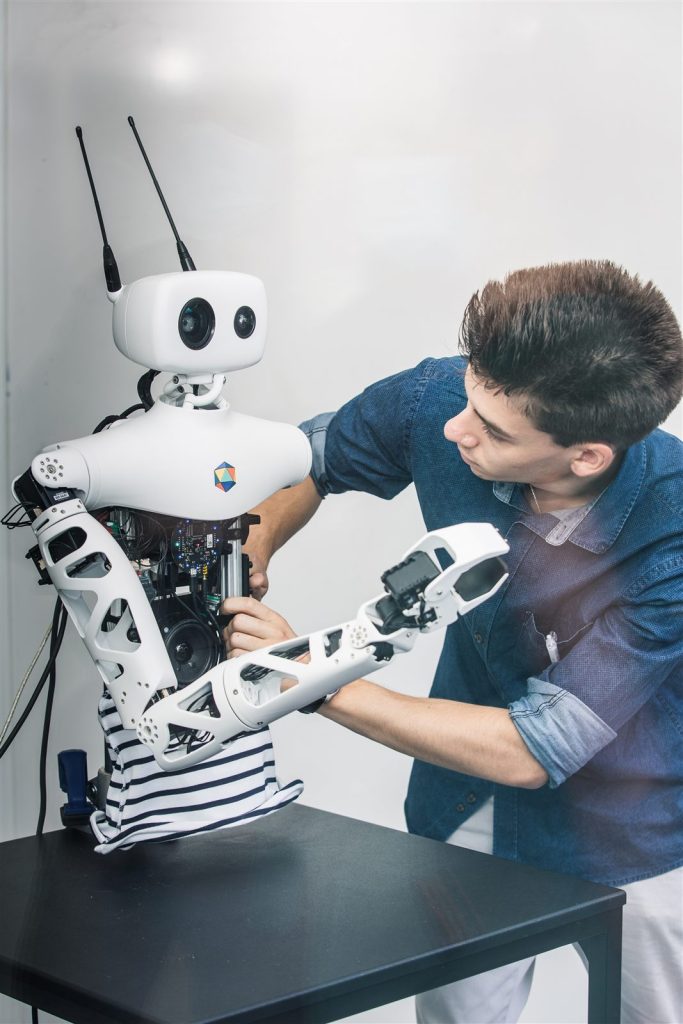 工程师在调试 Pollen Robotics 的 Reachy 机器人