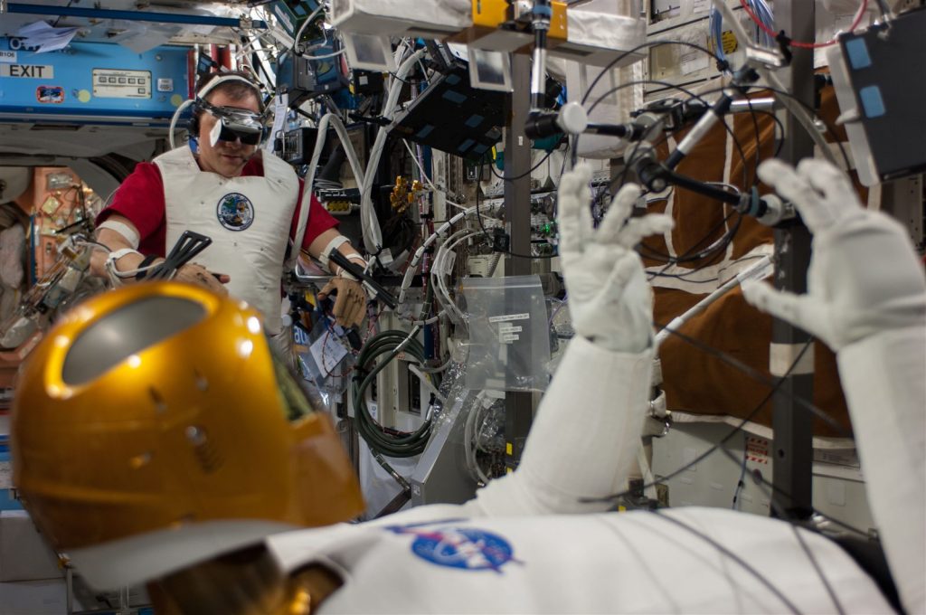 太空人戴头显与手部控制器遥控人形机器人 Robonaut 2